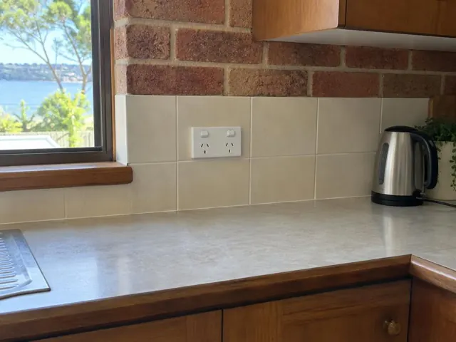 New double power point on tiled kitchen splashback above timber benchtop in Bolton Point